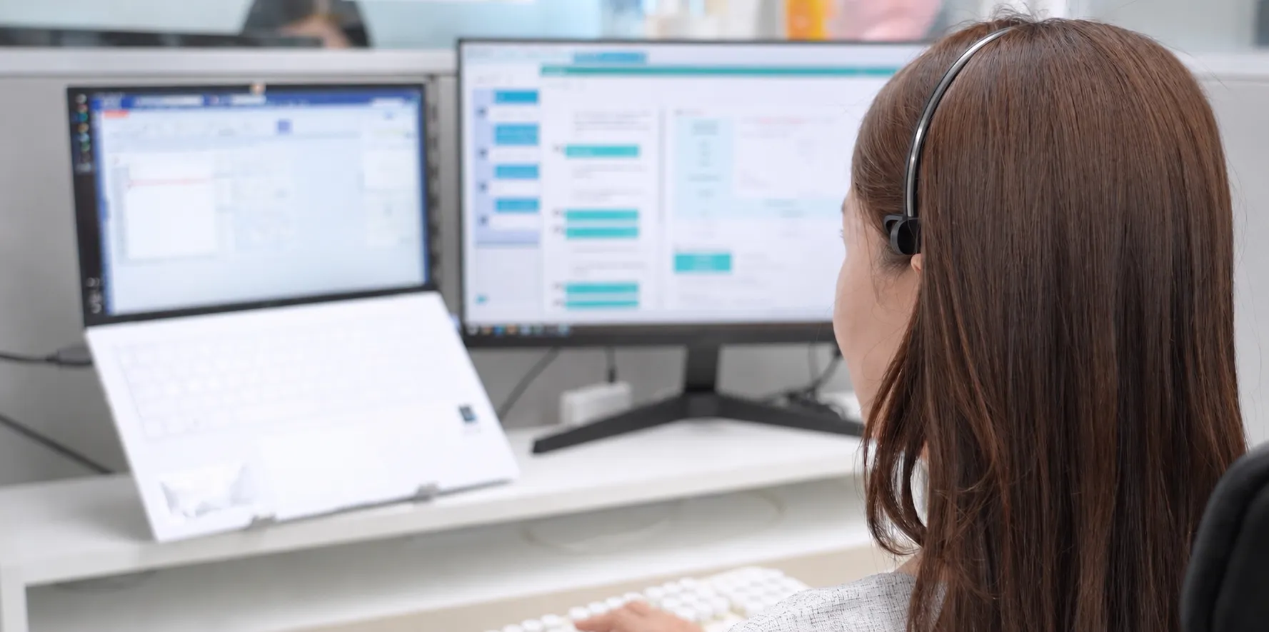 듀얼 모니터로 AI 상담Assist 화면을 보며 헤드셋으로 상담 중인 KTcs 상담사